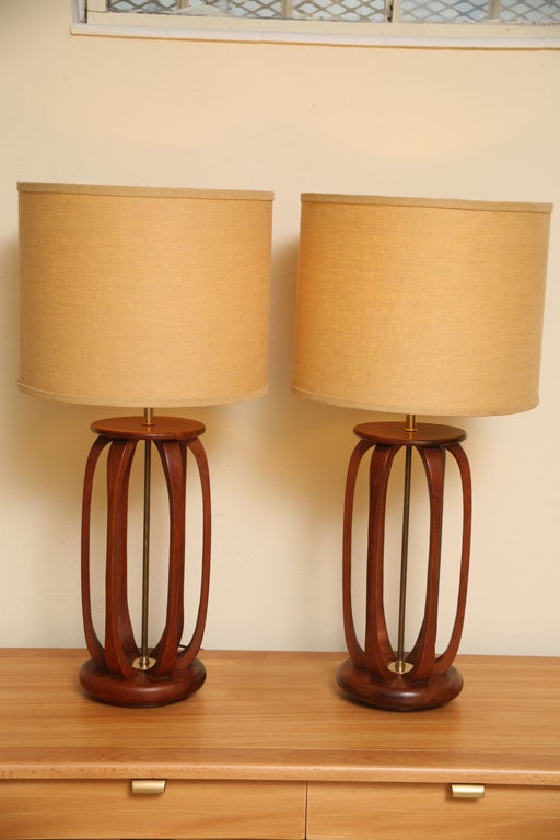 ...SOLD..  Elegant & warm sculptural teak highlights this pair of carved and shaped elongated barrel form mid century lamps with brass mounts and hardware.  Featuring vertical open ribs or staves with a socle base and top.  In exquisite condition,