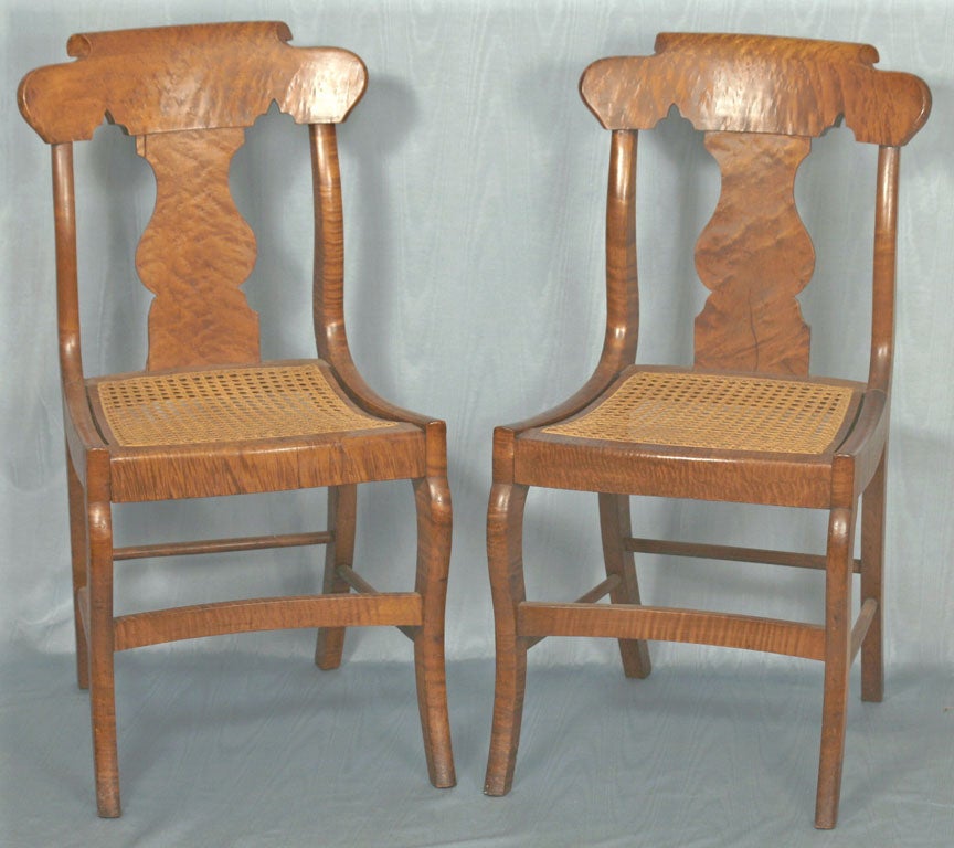 Dramatically figured maple and strong amber color combine to make these chairs the best of their type. All they need are your seat cushions with tassels to gild the lilly. The seats are hand woven cane. Probably made in New York State.