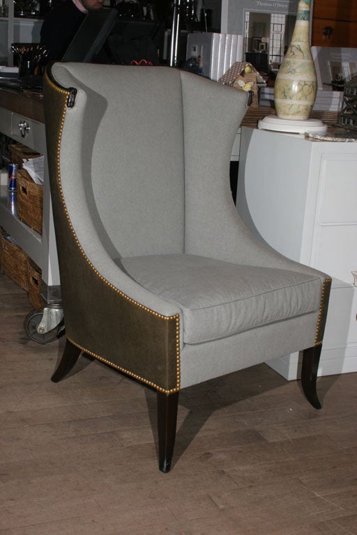 Loden twill upholstered wing chair by Grosfeld House with carved accents and contrast leather back and nailhead trim circa 1950