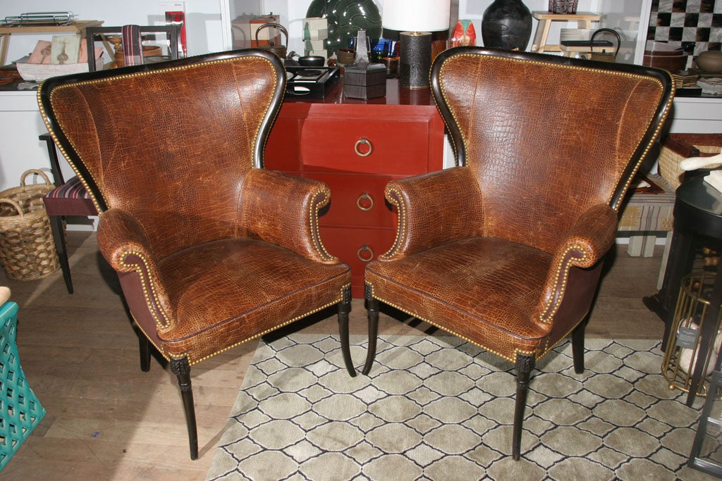 Pair of English style crocodile-embossed leather wingback chairs with contrasting leather backs, sable-finished carved wood frames, and natural nailheads circa 1920