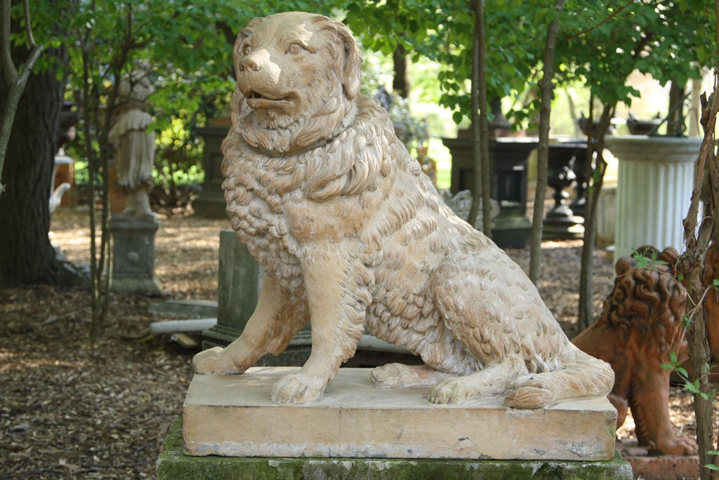 A terra-cotta dog seated at attention, with expectant gaze, on integral rectangular base.