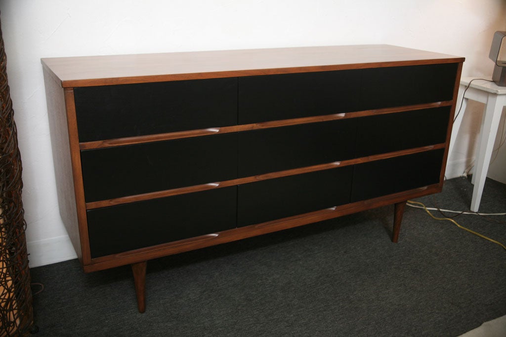 Dresser with nine satin black lacquered drawers...no handles: they opens thanks to elegant grooves on the body of the case..body and drawers linear dividers are refinished in original teak colour