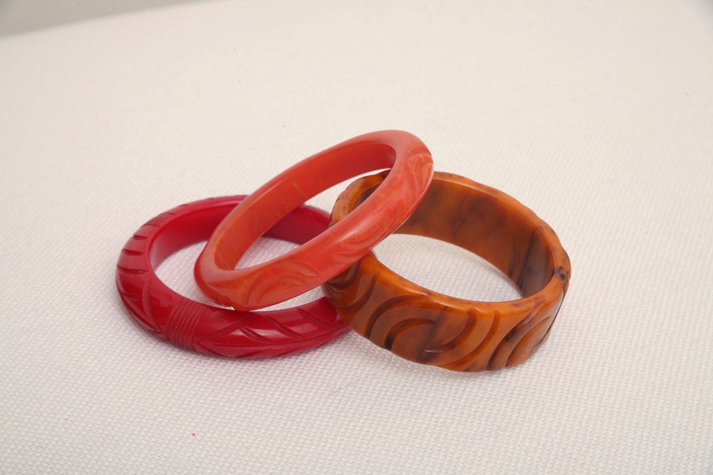 Set von drei roten, bernsteinfarbenen, orangefarbenen, geschnitzten Art-déco-Armbändern aus Bakelit Damen im Angebot