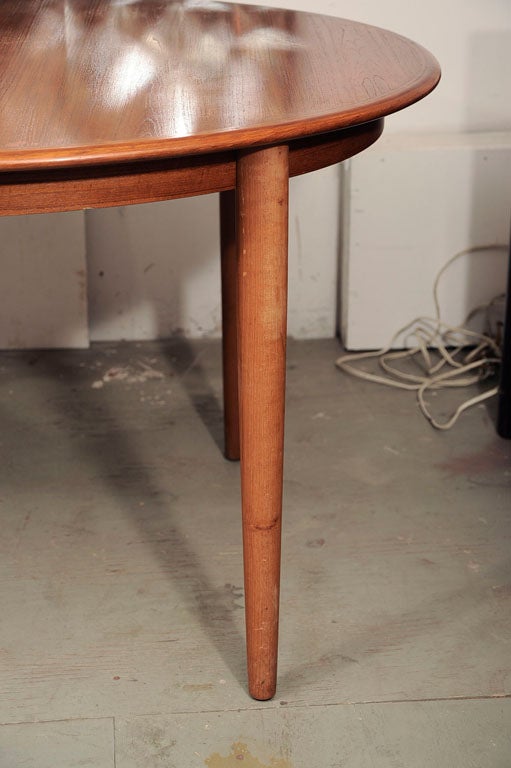 Danish modern teak dining table with two leaves/extensions. Please take note of the photos which show how the extensions are stored under the table and its length when extended. Each extension measures 19.75