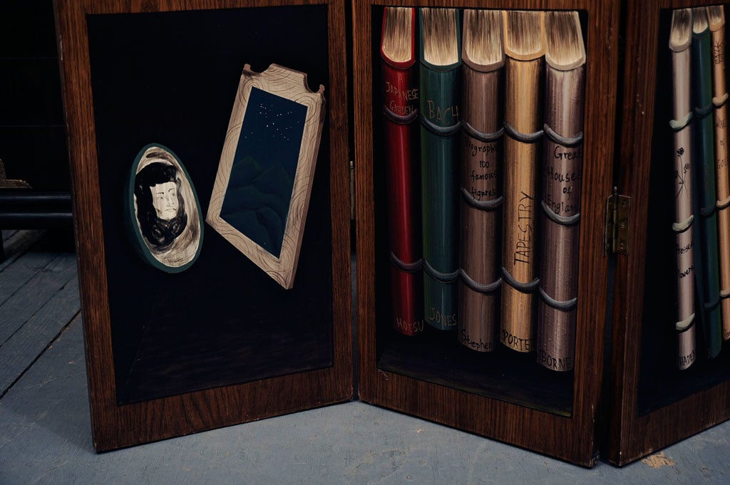 Charming folding screen with a trompe l'oeil of books.  The length and depth noted in the details below is when the screen is fully extended. When the screen is folded, the length is approximately 57 inches.  Please contact for location.