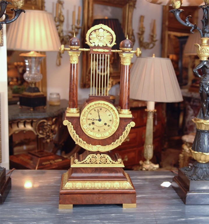 19th Empire beautiful flame mahogany and bronze dore trimmed Lyre clock. Signed and in good working order ringing on half and the whole. 8 day movement