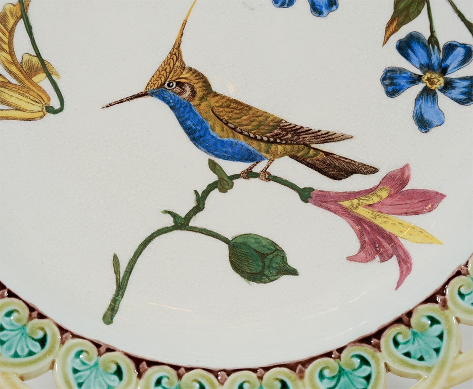 A group of 9 Wedgwood Majolica pierced plates each with its own distinct  decoration. Each of the plates shows a scene of flowers, birds and butterflies.