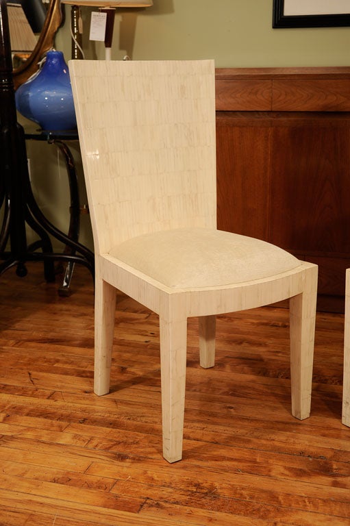 A set of 8 1970's chairs with bone marquetry done in the manner of Karl Springer. The bone is tiled over wood. The high backs taper slightly from the top towards the seat.<br />
<br />
Armchair: 38
