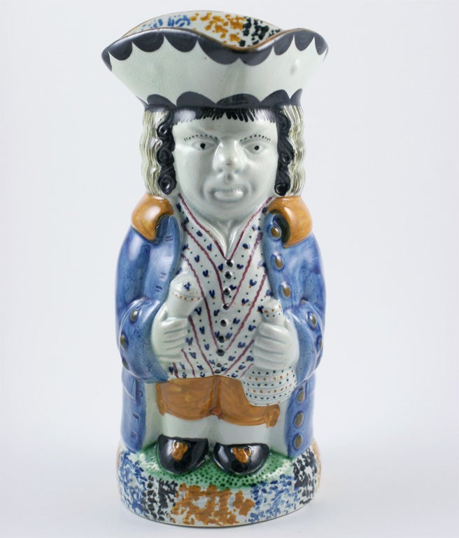 A fine Yorkshire pottery mid size toby jug with figural handle decorated in underglaze Pratt colors