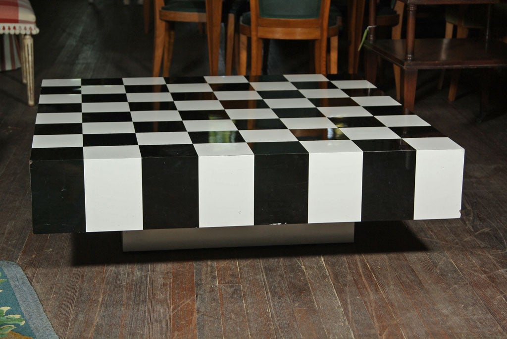 Table basse en stratifié plastique noir et blanc avec base plinthe encastrée.
