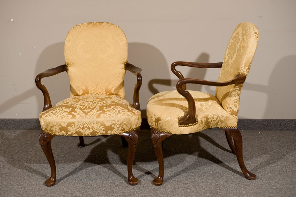 A classic designer's dream, these solid mahogany circa 1930's chairs are in their original rich patina finish and upholstered in a gold designer damask fabric that sets off the classic mahogany finish. These stunning chairs make a grand statement