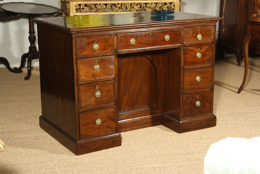 A late George III period mahogany architect's desk - the top raises to allow for drafting - having one central drawer flanked by four drawers on either side.