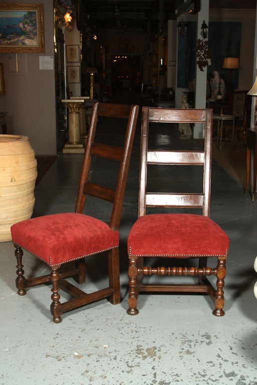 A near pair of French walnut side chairs both with moulded ladder backs and the bases with bold turned legs joined by turned stretchers.