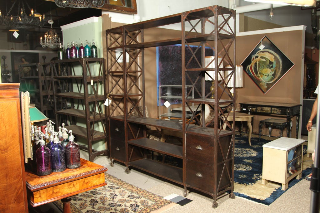 Fine entertainment unit made of wood and steel. Popular cross back sides and rear support the upper and lower shelves. The bottom four drawers sitting on metal casters. Great for the playroom.