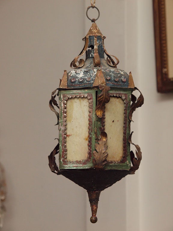 A small, polychrome hexagonal lantern with a pierced top with chimney.
