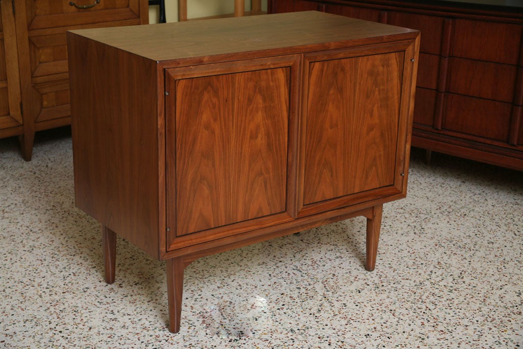 SOLD OCTOBER 2010....Beautiful warm walnut highlights this two door cabinet by Stewart MacDougall & Kip Stewart for Drexel, part of the noted Declaration Line of the late 50's, early 60's.  With heavily figured bookmatched walnut veneered doors that