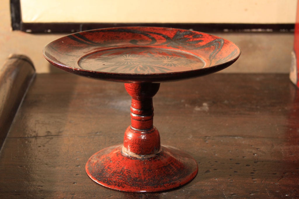 Japanese tall round footed tray (takatsuki) of negoro red lacquer with an overall dark patination. Footed trays such as this were used to serve food at formal occasions. The deep red tray with bold freehand decoration in iron oxide on the tray. The