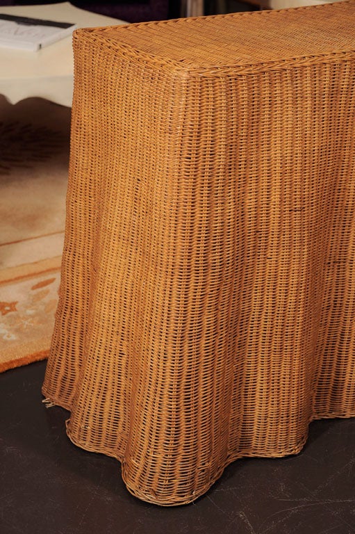 Console table in woven rattan, giving the appearance of draped fabric.
