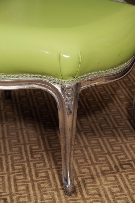 A fabulous ottoman made from cast aluminum in the Louis XV style, covered in acid green faux patent leather--old meets new.
