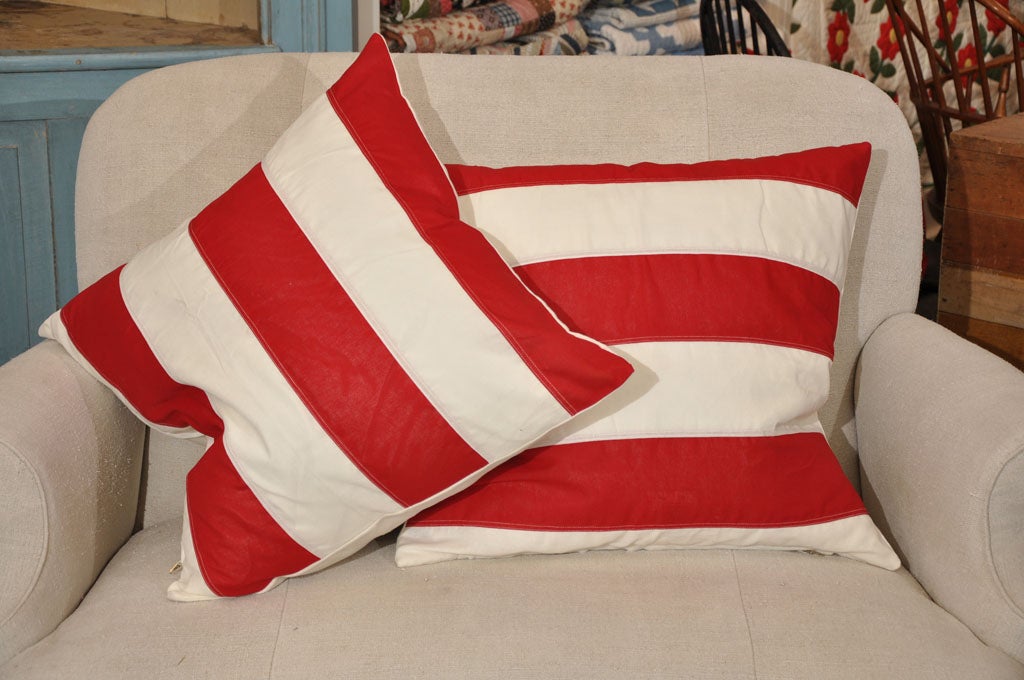 20TH C. COTTON/LINEN FLAG MATERIAL PILLOWS. FRONT SIDE IS RED AND WHITE STRIPED AND BACKING IS SOLID WHITE. DOWN FEATHER INSERTS. SOLD INDIVIDUALLY AT 225 EACH.