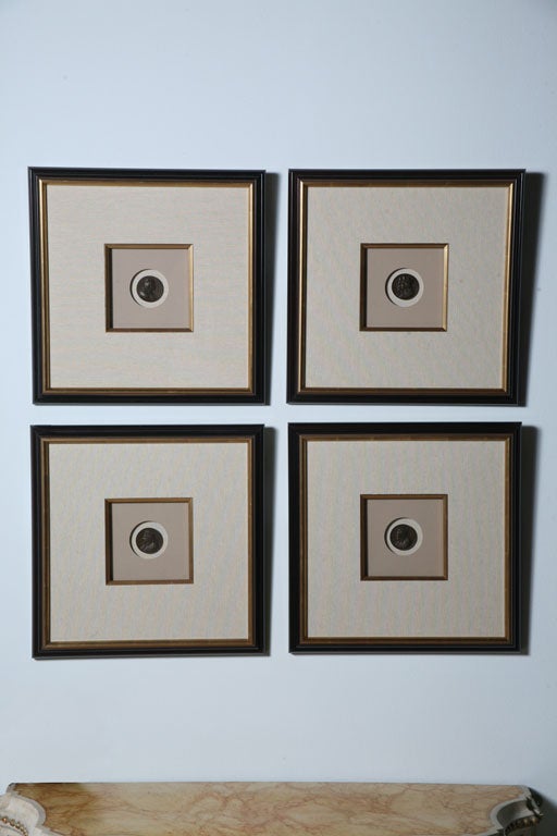The bronze coin within fine linen mats with gold leaf filets framed within an ebony and parcel-gilt frame.