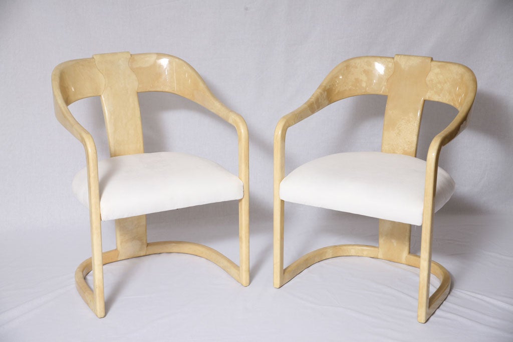 Matching set of four arm chairs for dining or lounge  with great curveture covered in natural tone goat skin. Upholstered in white micro suede.