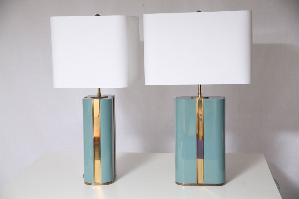 Superb pair of table lamps constructed of solid wood, with polished Aqua lacquer, and inset brass columns and fine detailing throughout. White rolled linen shades. Attributed to Karl Springer.