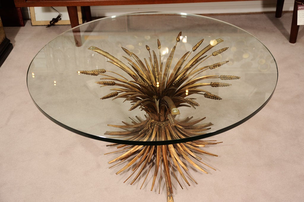 Italian Hollywood Regency style gilt tole metal sheaf of wheat coffee table with round glass top. The sculptural metal base depicts a sheaf of wheat tied with a rope supporting a 1/2