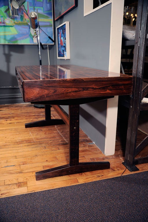 Rosewood Campaign style desk with 3 drawers. The rosewood veneer top sits on two solid rosewood legs with a single stretcher.