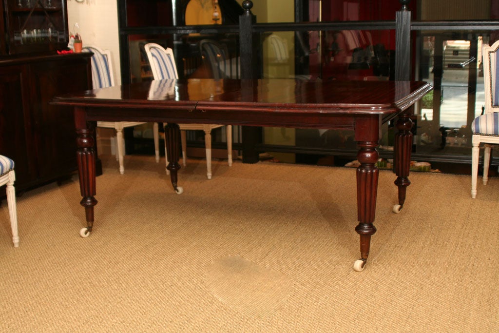 An exceptional William IV Rich mahogany extending dining table with turned and fluted legs on white porcelain castors

The leaf 37'' x 48.5''.