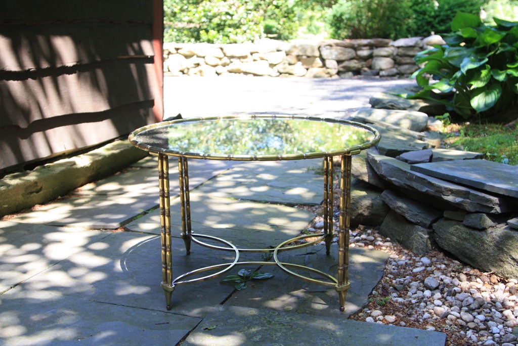 Faux bamboo style gilt bronze with a quatrafoil design stretcher and oxidized mirrored glass top