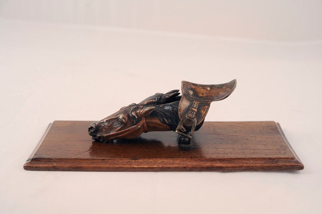 Rare and collectable Vienna cold-painted bronze paper-clip of two horse heads and saddle.  Mounted on wooden base.