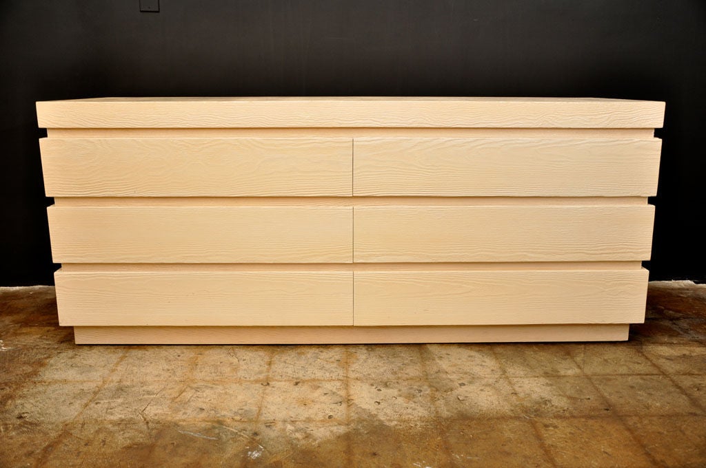 Long wood dresser with rough, raw like appearance. <br />
With a thick textured cream paint patina this piece is smooth to the touch but it maintains its rugged look exposing the natural waves of the wood.
