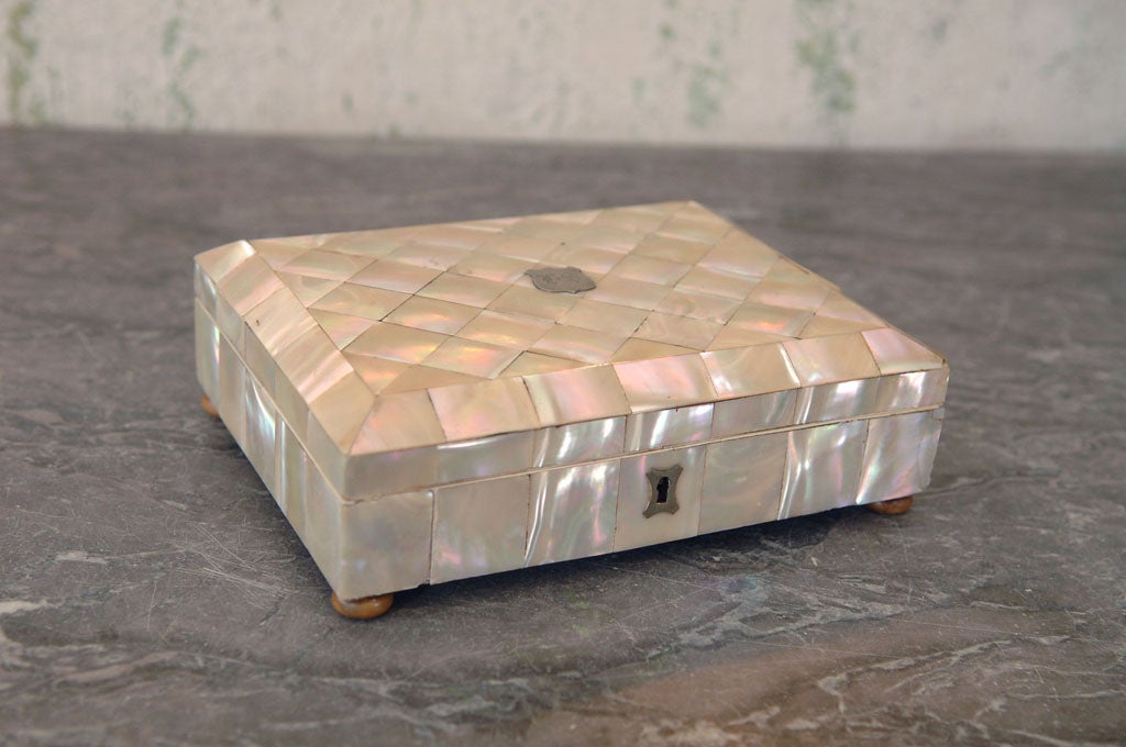 Beautiful Mother-of-Pearl Footed Vanity / Jewelry Box,<br />
with parquetry design veneer, silvered mounts and crest, and tufted silk fabric interior