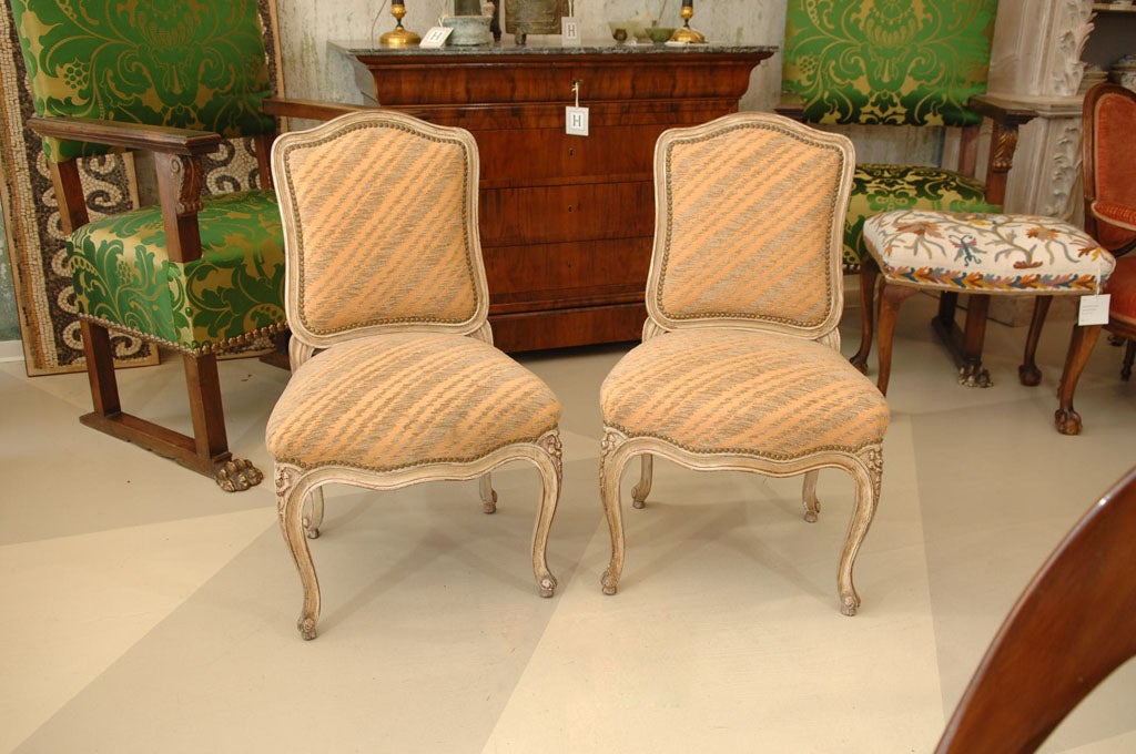 Wonderful Pair of Maison Jansen Painted Side Chairs, <br />
having carved and ornamented wood frames with upholstered seat and backs, <br />
and nailhead trim