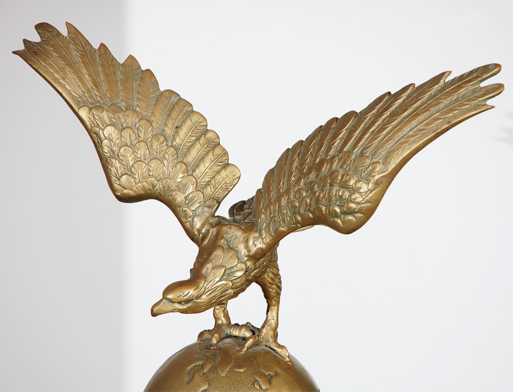 THIS FOLKY RARITY IS MOUNTED ON A IRON STAND.THIS LARGE OVER SIZED EAGLE SITS ON A BALL,WHICH IS THE EARTH.THIS IS SOLID BRASS AND SITS ON A CUSTOM MADE IRON MOUNT.THIS IS FROM THE TOP OF A FLAG POST,PROBABLY A FEDERAL BUILDING.THIS IS FROM A
