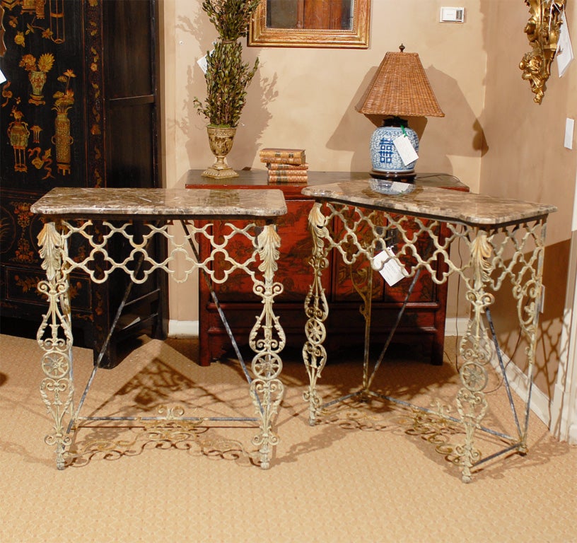 A contemporary custom made console from 19th century reclaimed iron bits and topped with a rectangular top with rounded corners.  The top is of port laurent, a Moroccan limestone, set in a patchwork design.   The top rests on a two tier quatrefoil