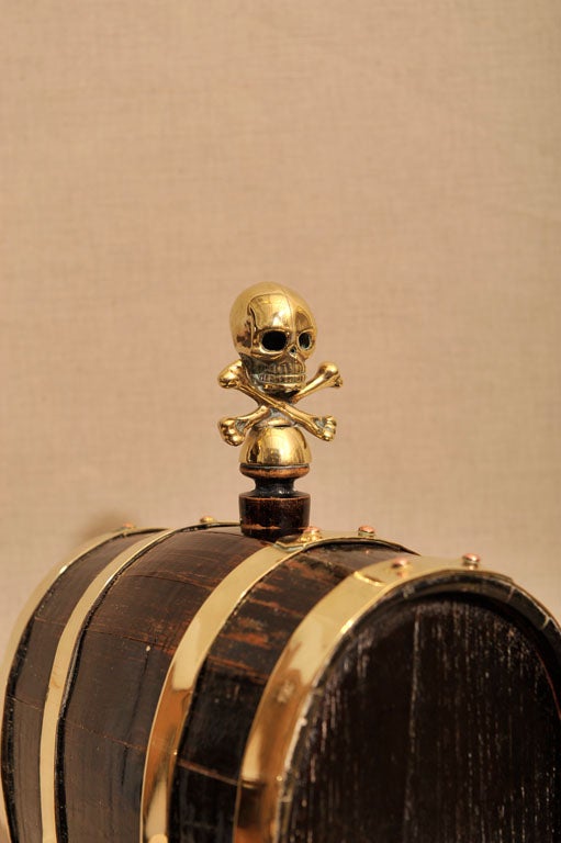 Unusual Brass Bound Oak Rum Keg, on Oak Stand, Featuring a Pirate Motif Skull and Cross Bone Corked Top, England, Late 19th Century<br />
<br />
(14 inches long / deep x 17 inches tall)