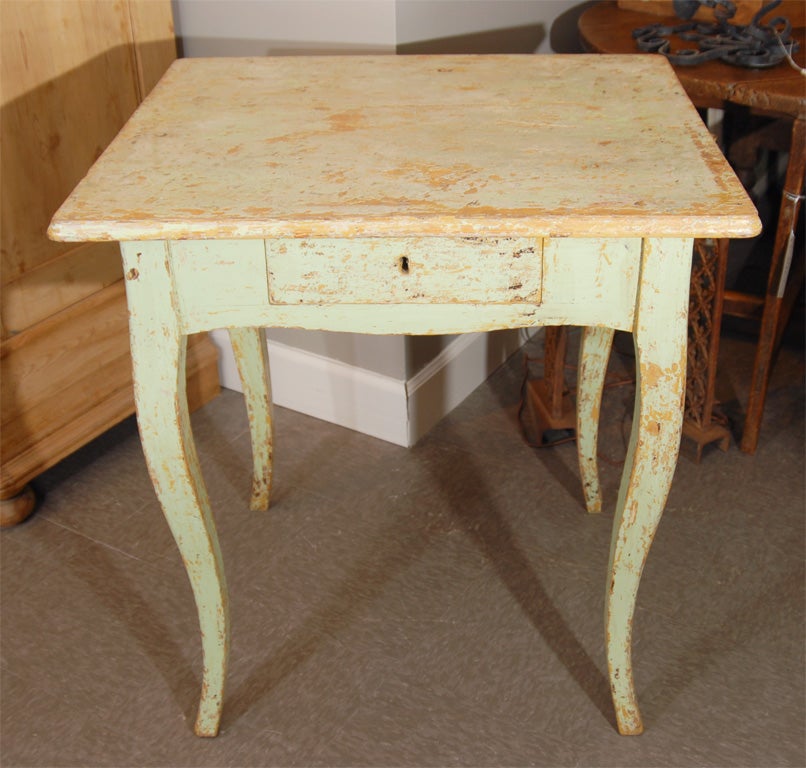 Painted side table with a scrub top (still with some old paint), shaped aprons, slightly cabriole legs and one drawer.  France.