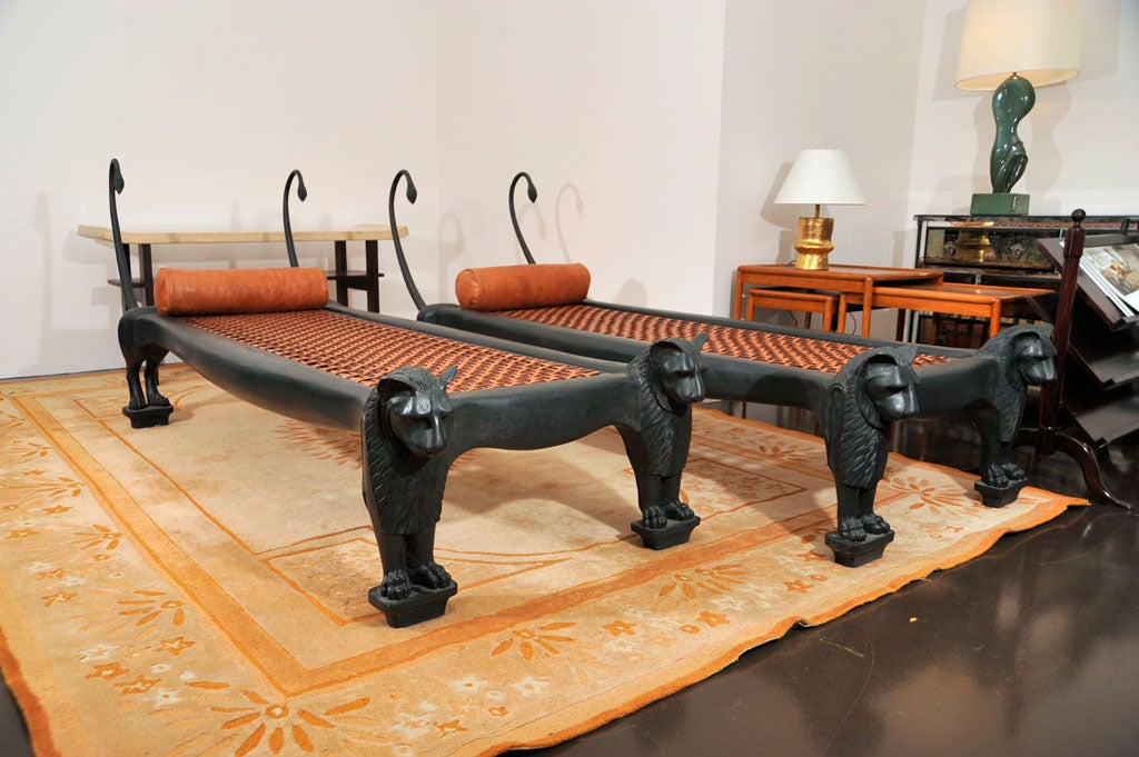 Glamorous hand-carved ebonized wood daybed with leather webbing and bolster pillow.