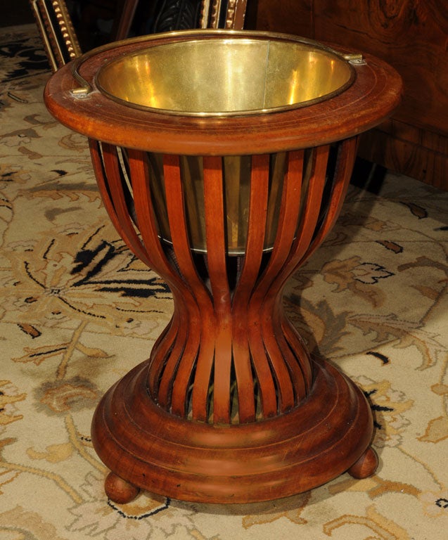 A handsome Edwardian plant stand of mahogany with a brass handle and a fitted brass jardiniere insert. <br />
Featuring an hourglass shape, the top and bottom tiers have inlaid stringing around each circumference with a column support of bentwood