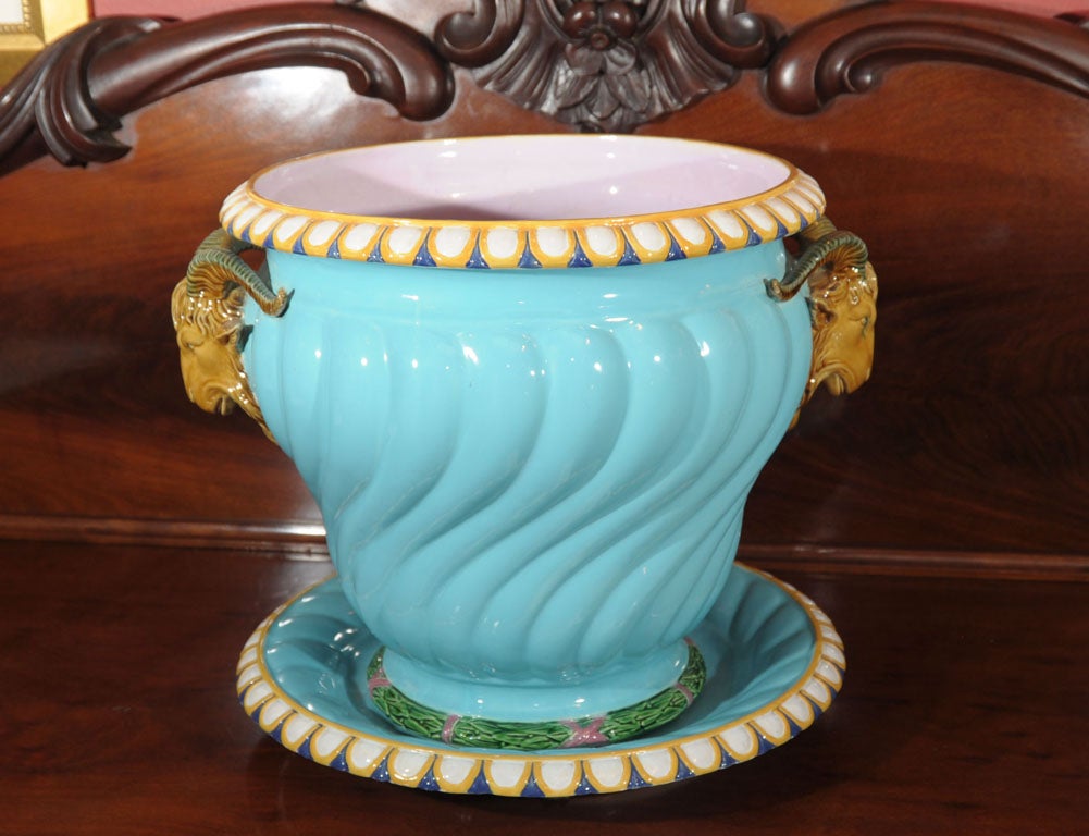 A magnificent Majolica jardiniere with undertray by the celebrated pottery firm, Minton, featuring a lovely robin's egg blue exterior on a spirally fluted, tapered body, the top edge with an egg-and-dart pattern in blue, yellow gold and white, the
