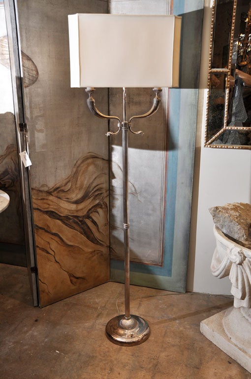 Silver Plated bronze 2 light floor lamp with fluted column mounted on a tiered base. Two dolphin supporting wax candle sleeves that house edison socket light fixtures are capped with a beautifully shaped 8 sided silk shade.