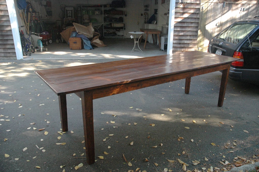 An unusually long farmhouse-style dining table in highly polished 19th Century wood with a beautiful grain and patina.  Can seat 10-12.