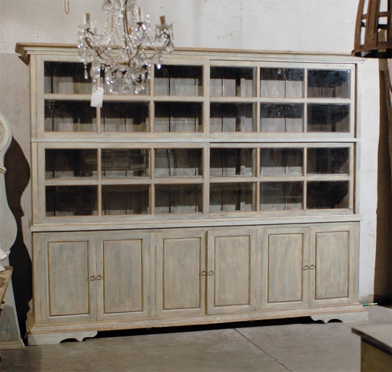 A large size American sliding glass door painted wood china cabinet with later base added with ample room for storage needs. The top part if this large cabinet is original and from the mid-20th century. The base is made out of old doors. The glass