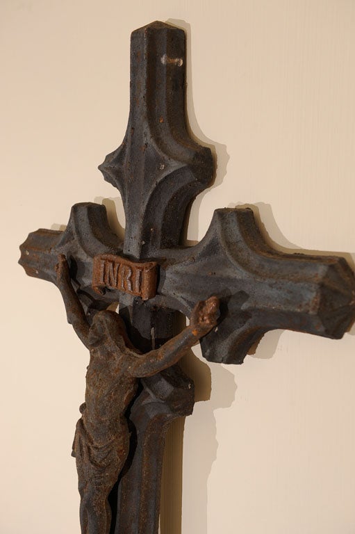 A large village crucifix, the corpus hands in the form of Christ Pantocrator with scrolled INRI plaque above. The cross is fluted and flared in the horizontal and vertical, the base with a three layer shell-like motif.