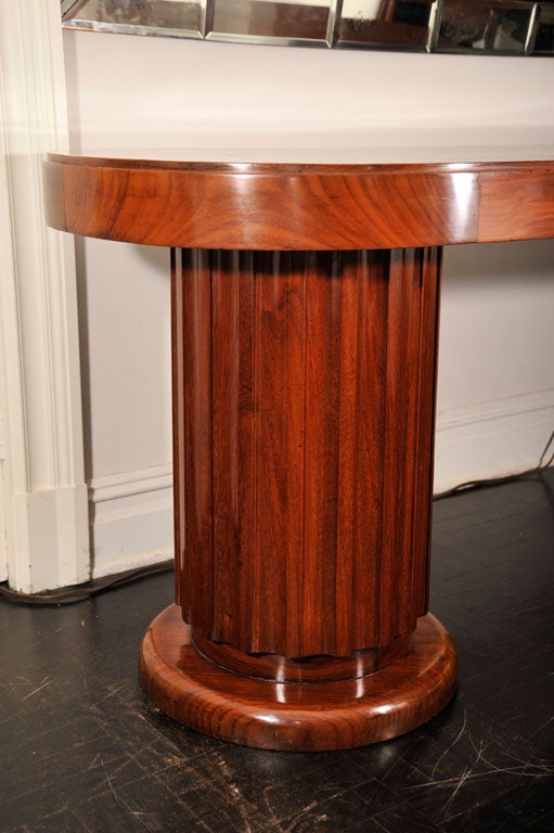 Early 20th century mahogany oval centre table. Pair of columnar fluted pedestals on circular bases, polished top.