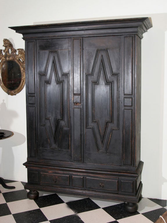 A Swedish Baroque black painted cabinet with two doors and a large drawer.