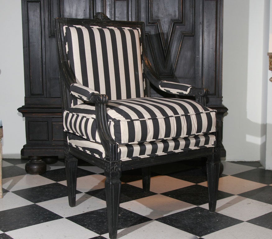 Armchair Black Swedish Gustavian 19th century Sweden. An armchair made during the Gustavian period 1790-1810. Black painted with carvings, tapered and reeded legs and . Upholstered in a black and white striped cotton fabric. Seat with a loose
