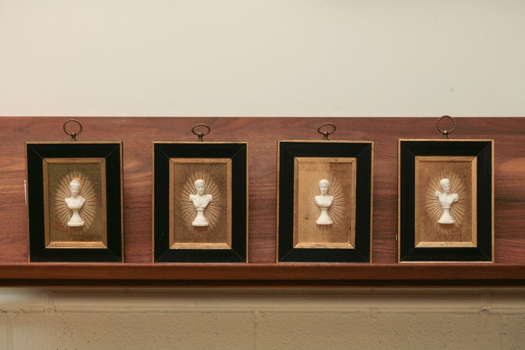Here is a set of plaques featuring bisque Roman busts of two men and two women. The glass is gold leaf backed and features a radiating starburst motif painted behind each figure.
